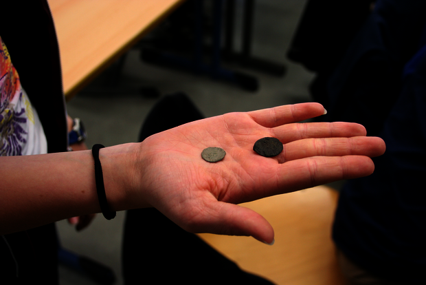 Foto von zwei antiken römischen Münzen auf einer Hand.